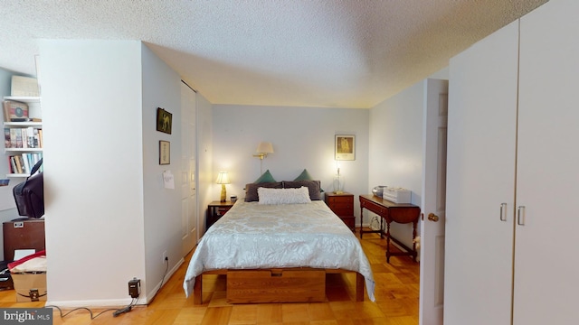 bedroom featuring a textured ceiling and light hardwood / wood-style flooring