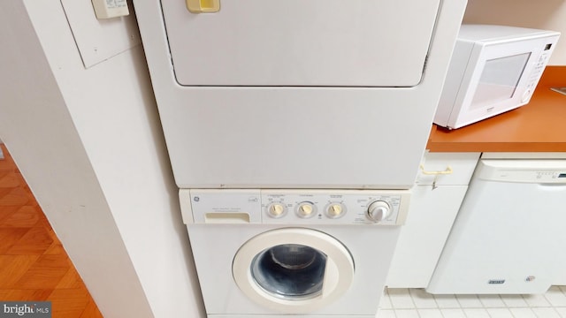 laundry room with light tile patterned floors and stacked washer / dryer