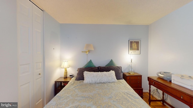 bedroom with dark hardwood / wood-style flooring and a closet