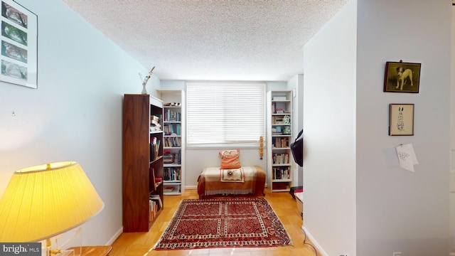 living area with light hardwood / wood-style floors and a textured ceiling