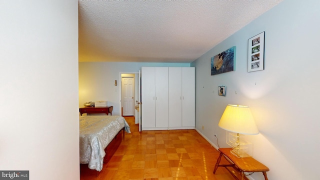 bedroom featuring a textured ceiling and light parquet flooring