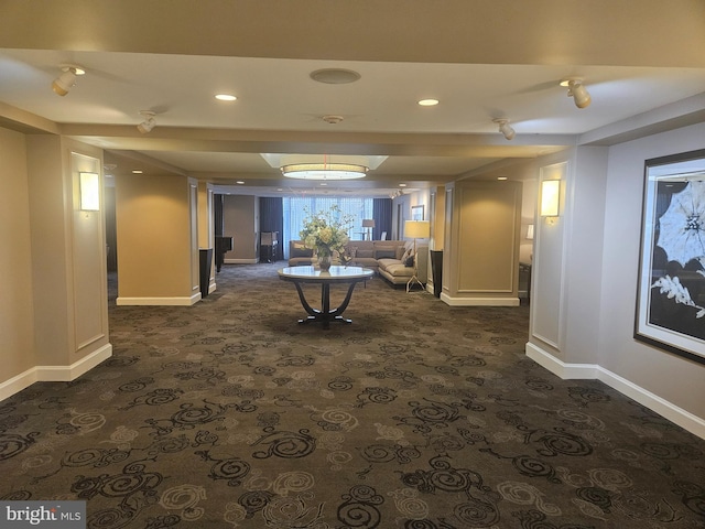 hall featuring dark colored carpet