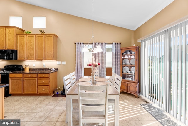 kitchen with lofted ceiling, decorative light fixtures, black appliances, and a wealth of natural light