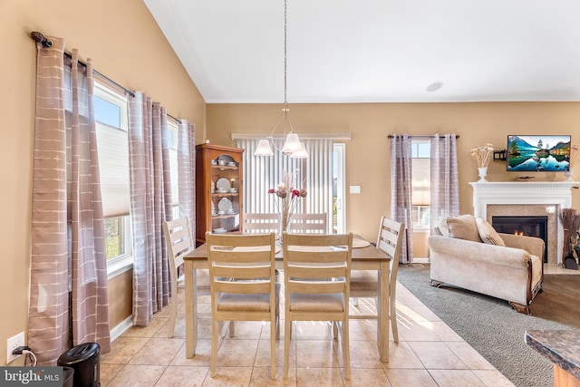 tiled dining space with vaulted ceiling and a notable chandelier