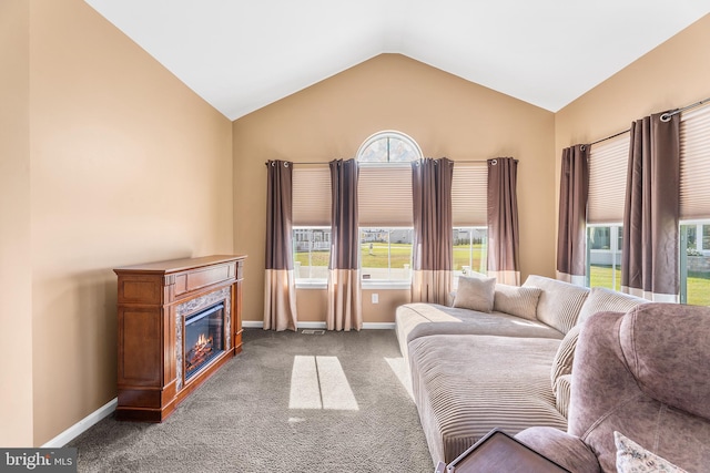 carpeted living room with a high end fireplace and vaulted ceiling