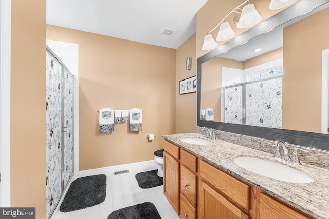 bathroom with vanity, toilet, tile patterned floors, and walk in shower