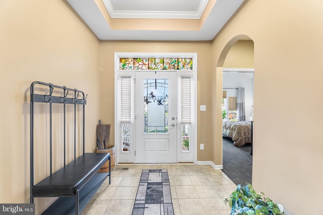 carpeted foyer entrance featuring crown molding and a raised ceiling