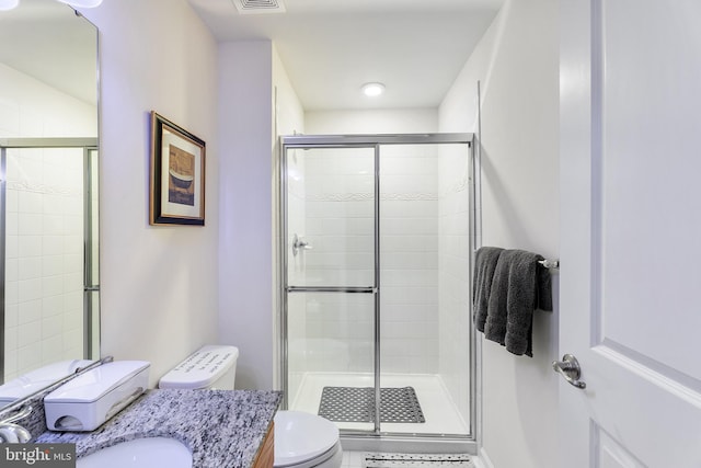 bathroom with toilet, an enclosed shower, and vanity