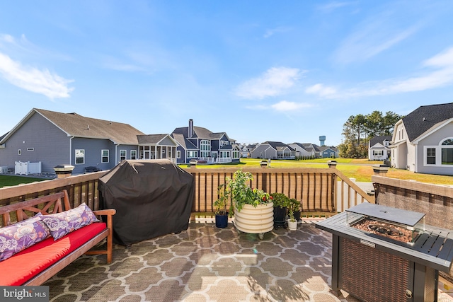 view of patio featuring a wooden deck, an outdoor living space with a fire pit, and grilling area