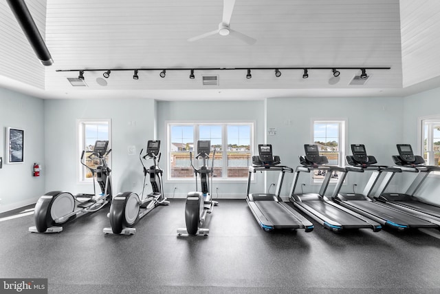 exercise room with ceiling fan, track lighting, and plenty of natural light