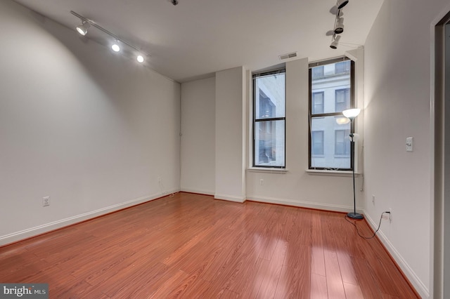 spare room with light hardwood / wood-style flooring and track lighting