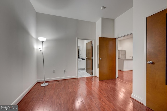 interior space featuring stainless steel fridge, light hardwood / wood-style floors, and ensuite bathroom