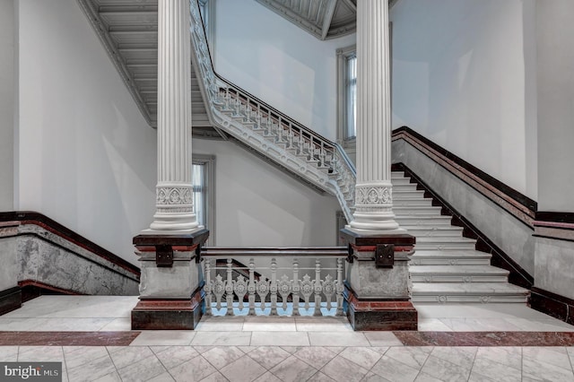 stairway with a towering ceiling and ornate columns