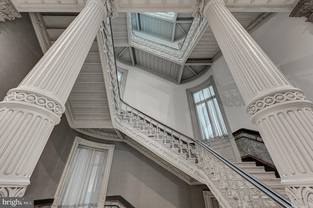 stairs featuring a towering ceiling and crown molding