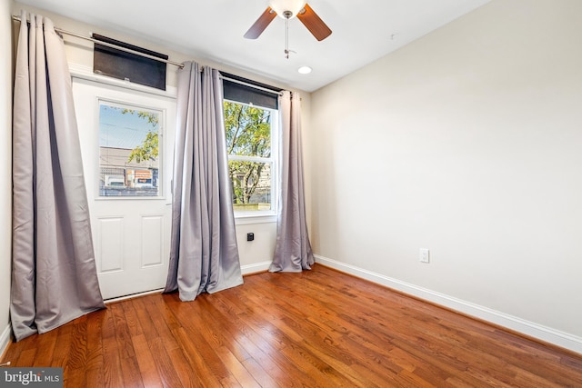 empty room with hardwood / wood-style flooring and ceiling fan