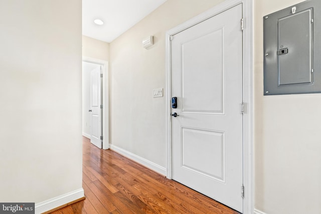 hallway featuring electric panel and wood-type flooring