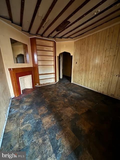 unfurnished living room with wooden walls