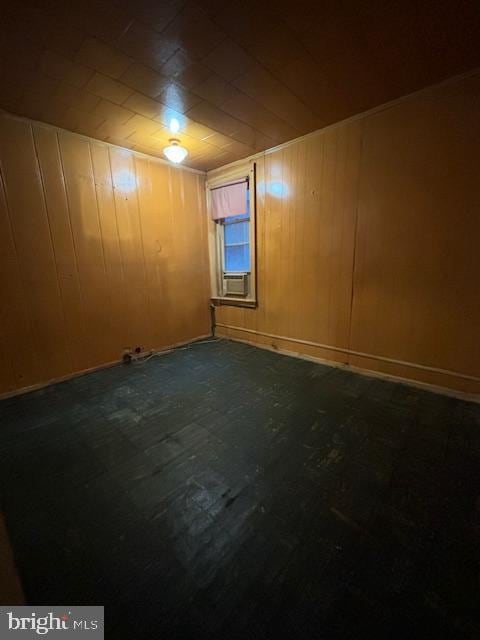 basement featuring cooling unit and wooden walls