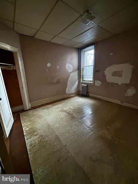 basement with radiator heating unit and a paneled ceiling