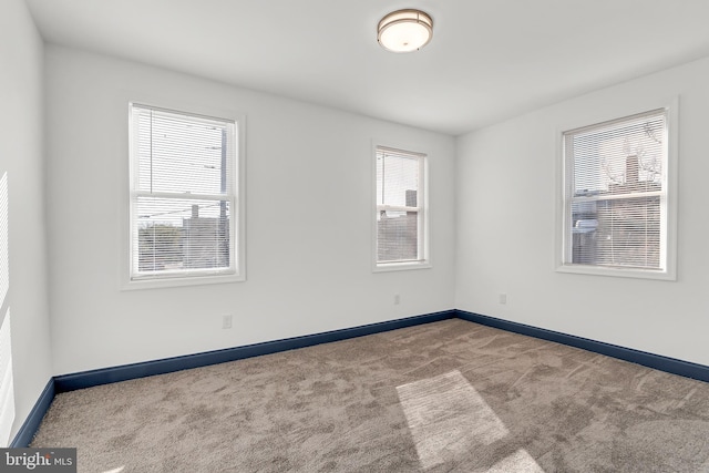 spare room with plenty of natural light and carpet