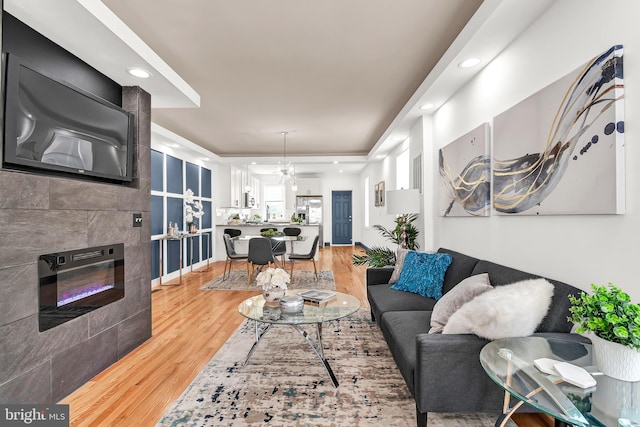 living room with hardwood / wood-style floors, a chandelier, and tile walls