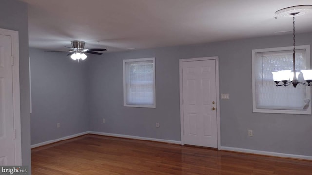 interior space featuring ceiling fan with notable chandelier and wood-type flooring