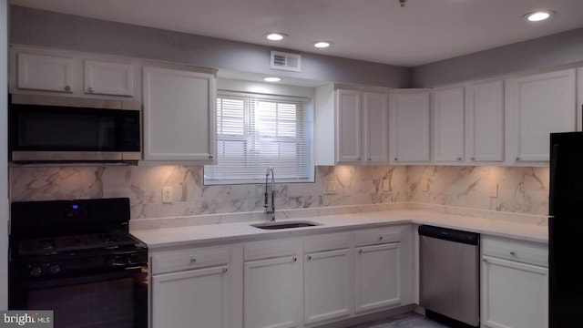 kitchen with black appliances, tasteful backsplash, white cabinets, and sink