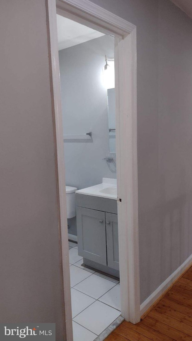 bathroom featuring toilet, wood-type flooring, and vanity