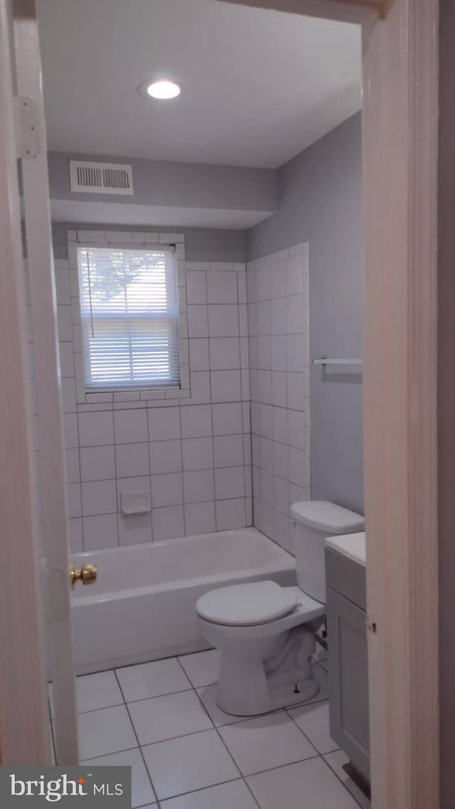 full bathroom with toilet, tiled shower / bath combo, tile patterned floors, and vanity