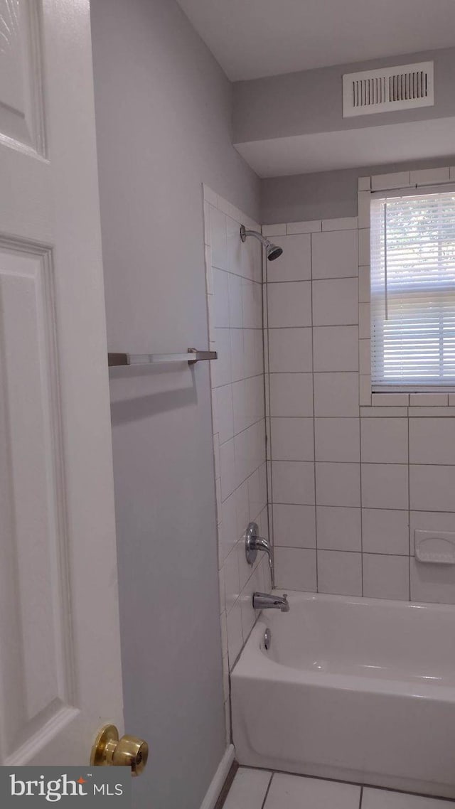 bathroom with tiled shower / bath and tile patterned floors