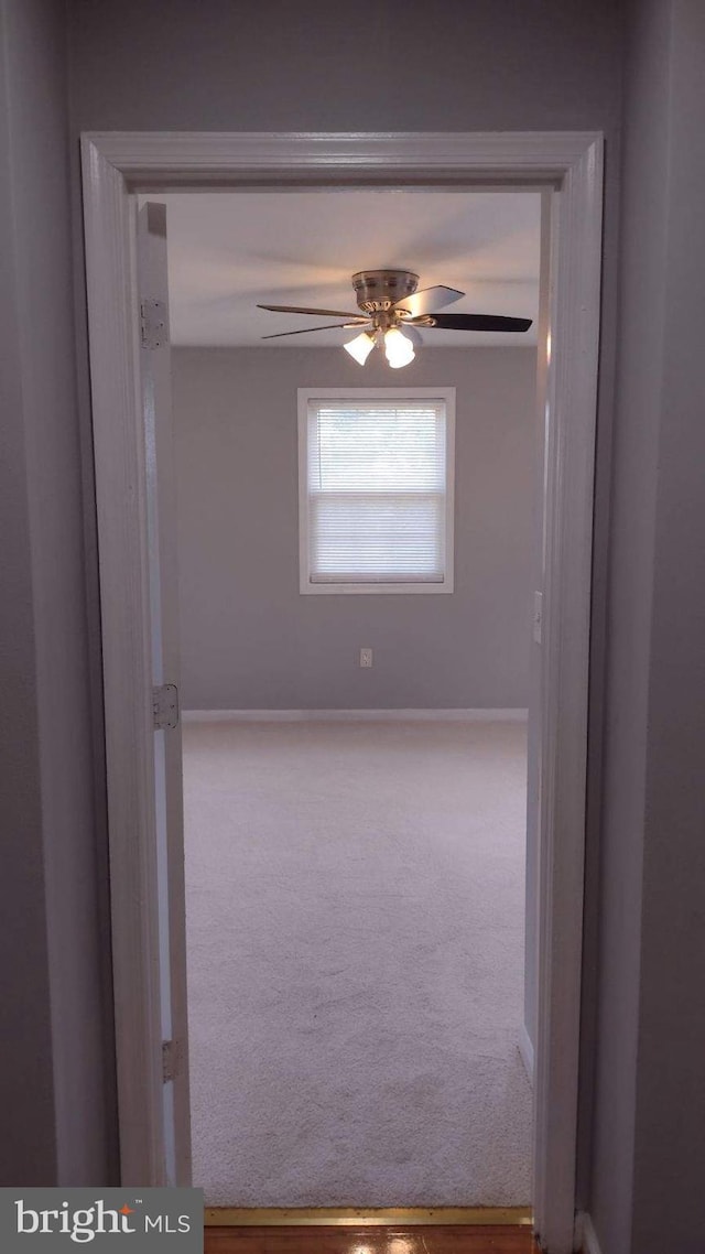 carpeted empty room featuring ceiling fan