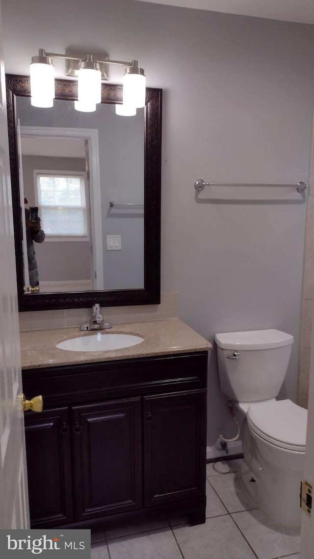 bathroom featuring toilet, tile patterned flooring, and vanity