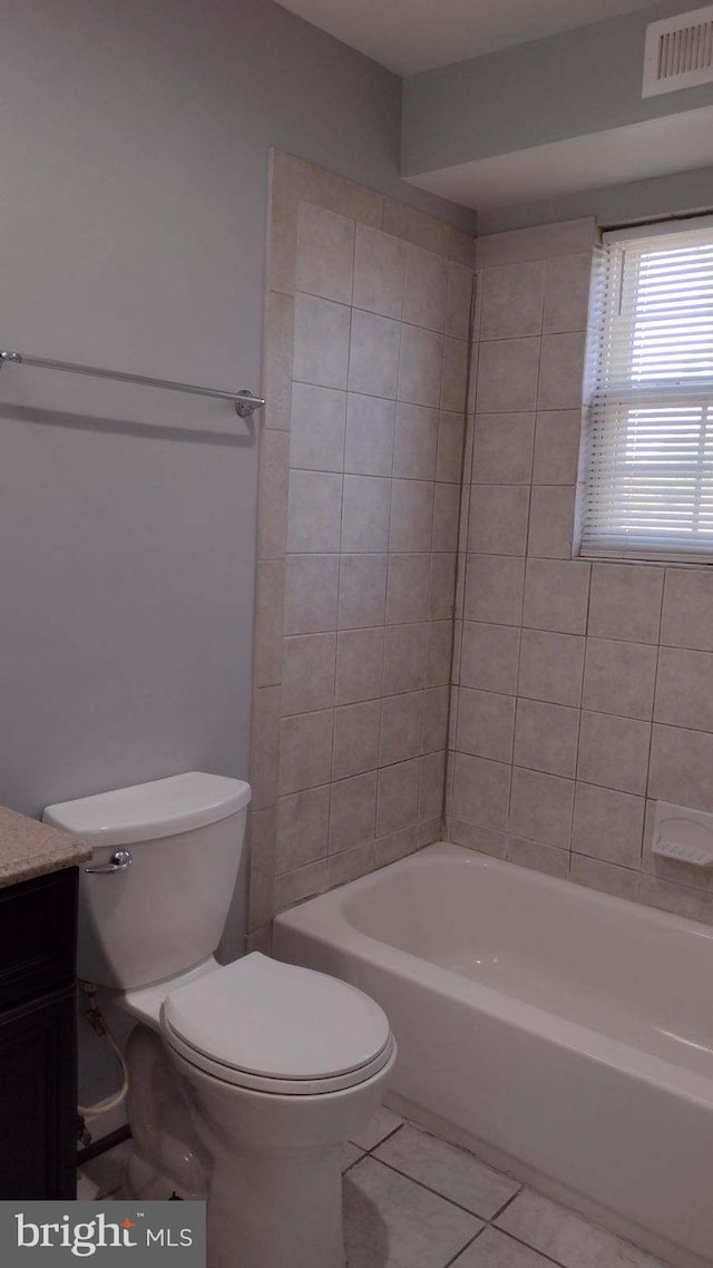 full bathroom featuring toilet, tiled shower / bath combo, tile patterned flooring, and vanity