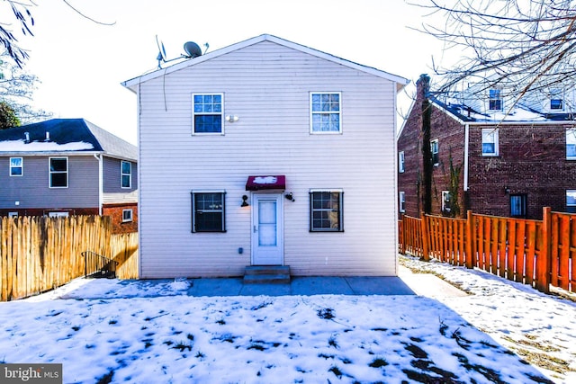 view of snow covered rear of property