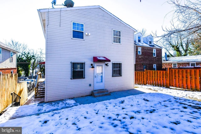 view of snow covered back of property