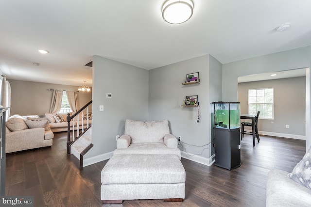 living area featuring an inviting chandelier and dark hardwood / wood-style flooring