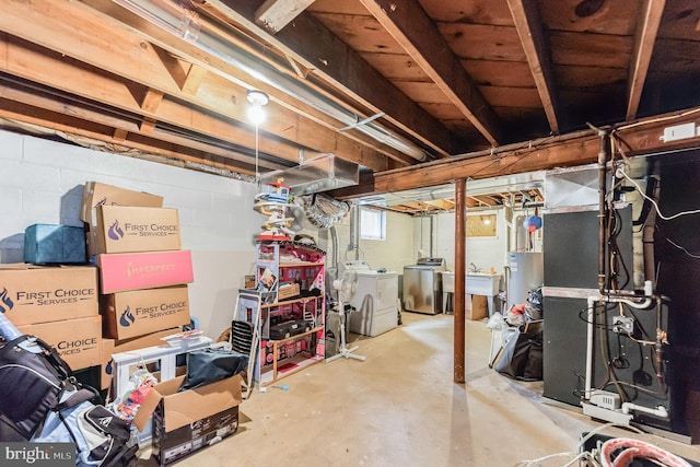 basement featuring heating unit, washer and dryer, and water heater