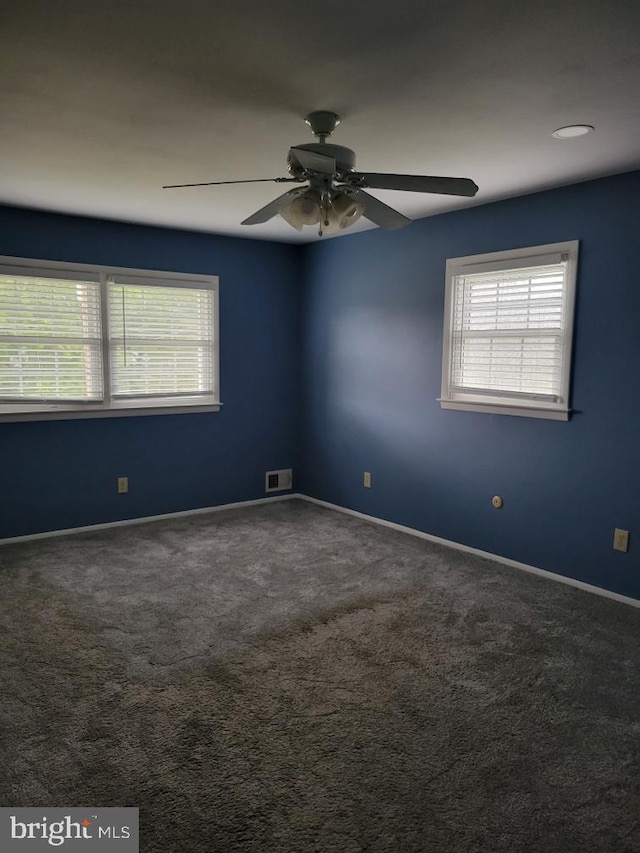 unfurnished room featuring ceiling fan, carpet, and a healthy amount of sunlight