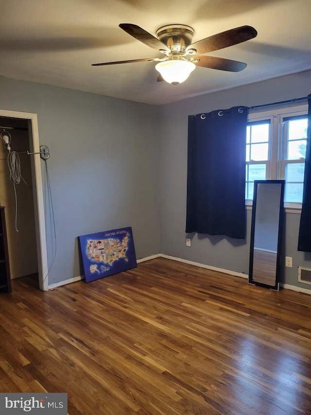 empty room with ceiling fan and dark hardwood / wood-style floors