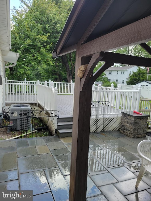 deck with a patio area and cooling unit