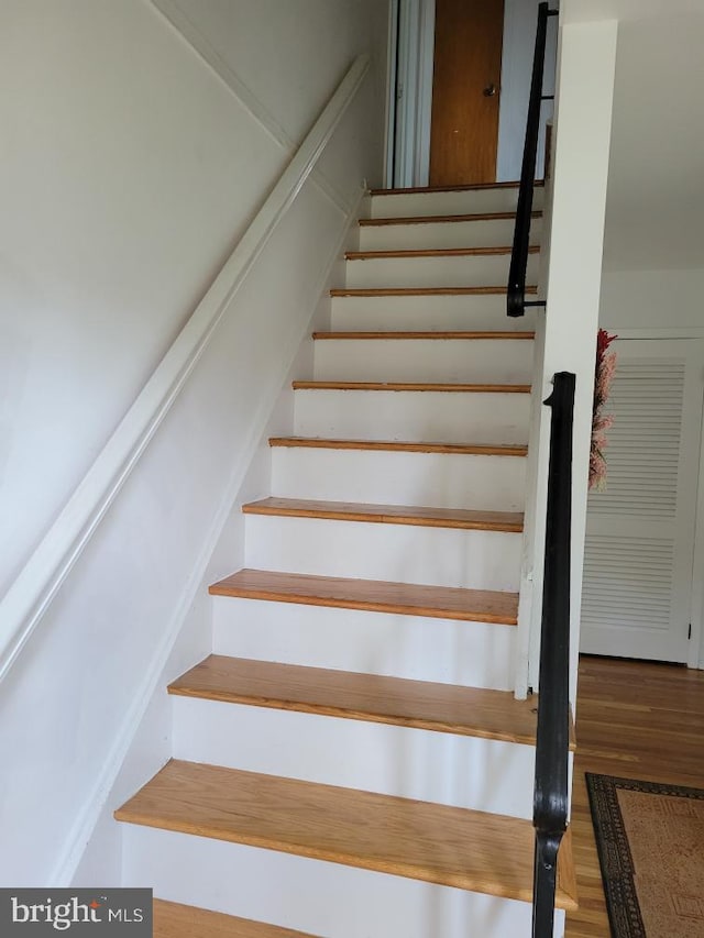 stairway with hardwood / wood-style floors