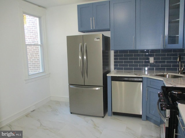 kitchen featuring blue cabinets, sink, tasteful backsplash, light stone countertops, and appliances with stainless steel finishes