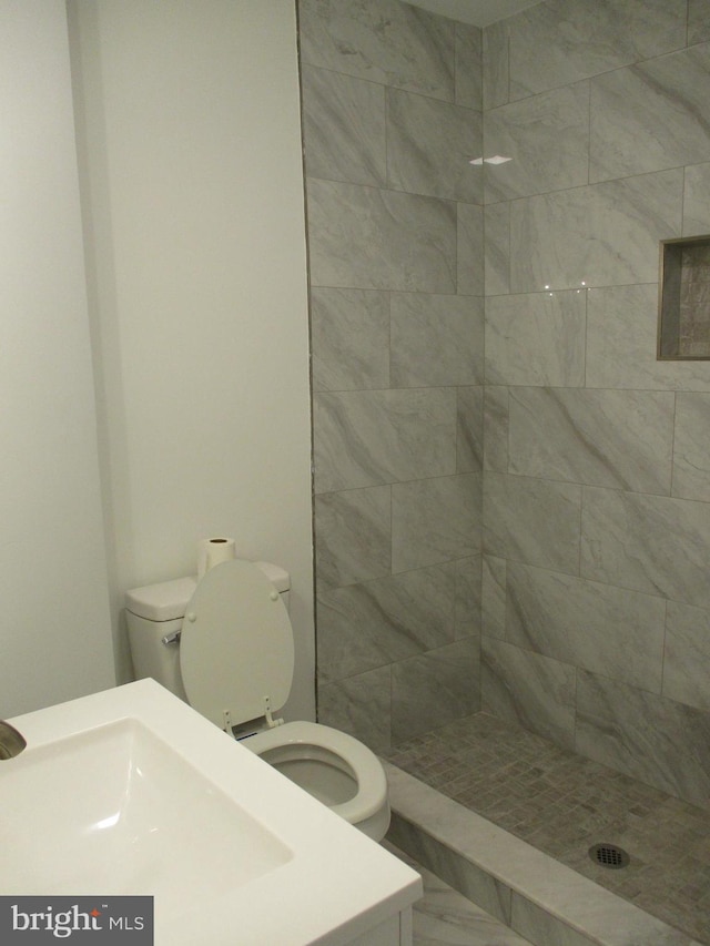 bathroom with toilet and tiled shower