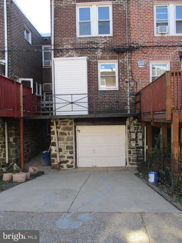 back of property featuring a garage and a deck