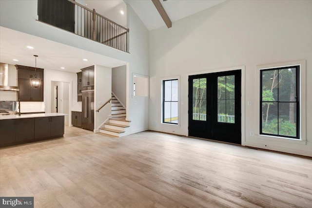 foyer featuring beamed ceiling, light hardwood / wood-style floors, high vaulted ceiling, and french doors