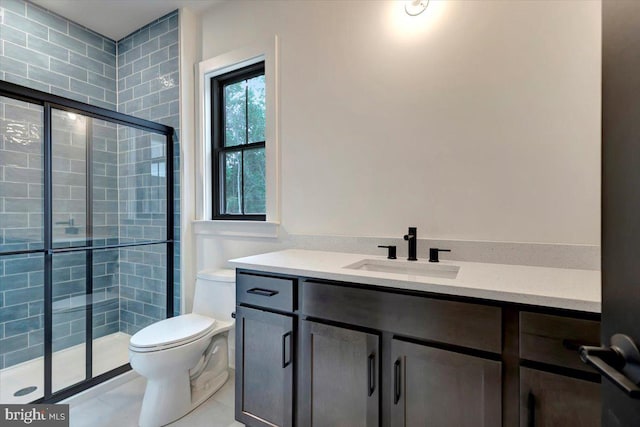 bathroom with tile patterned floors, vanity, toilet, and a shower with shower door