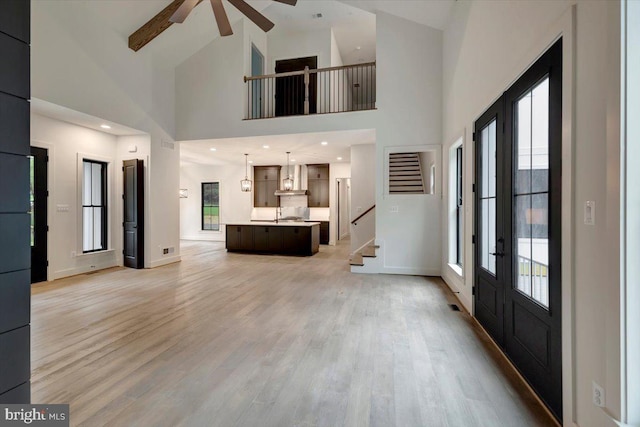 foyer with hardwood / wood-style flooring, high vaulted ceiling, a wealth of natural light, and ceiling fan