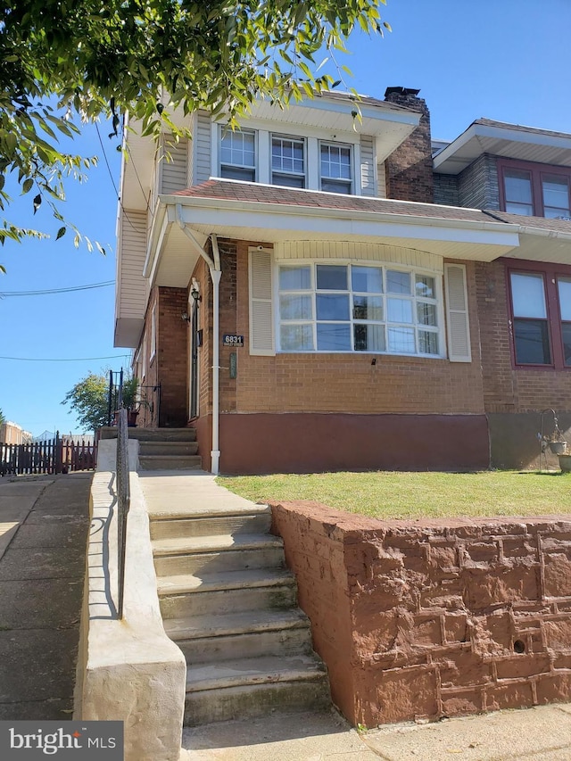 view of front of house with fence and brick siding