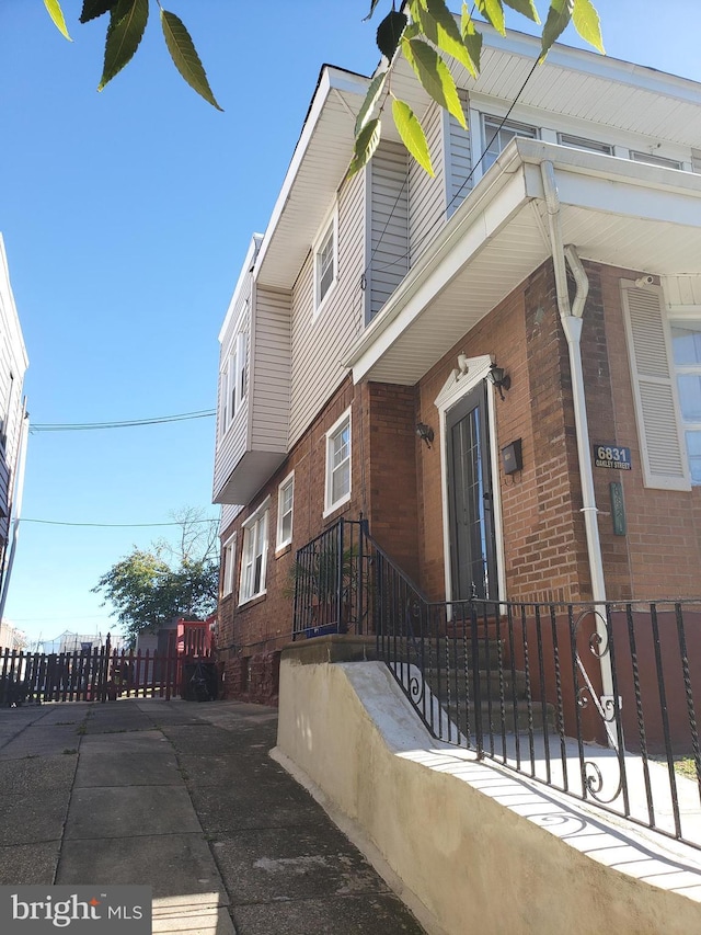 view of side of property with brick siding and a fenced front yard