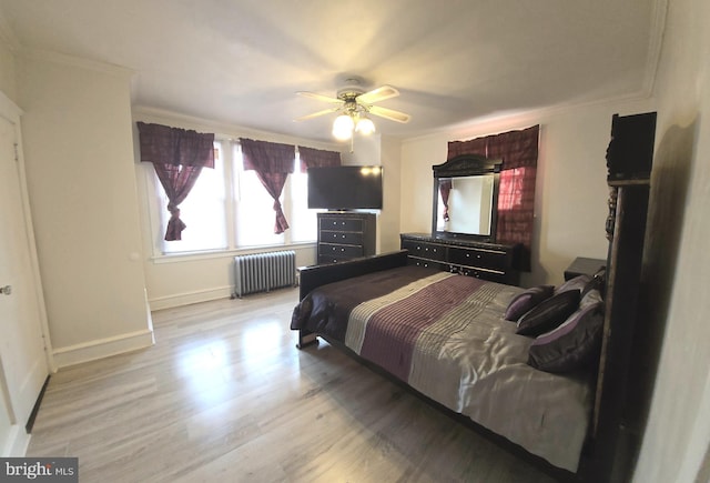bedroom with baseboards, ornamental molding, light wood-style flooring, a ceiling fan, and radiator heating unit